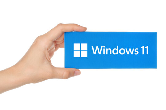 : Woman Hand, which holding Windows 11 paper logotype, isolated on transparent background. Windows 11 is an operating system developed by Microsoft