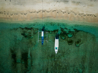 Boats attached to beach view with clear water aerial view