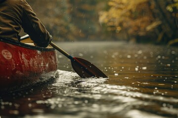 A person in a red canoe paddling down a river. Suitable for outdoor and adventure concepts