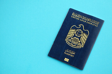 Blue United Arab Emirates passport on blue background close up. Tourism and citizenship concept - obrazy, fototapety, plakaty