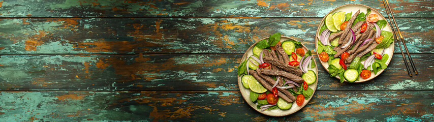 Two plates with traditional Thai beef salad with vegetables and mint top view served on rustic wooden background, healthy exotic asian meal. - 761508029