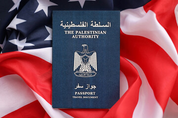 Blue Palestinian Authority passport on United States national flag background close up. Tourism and...