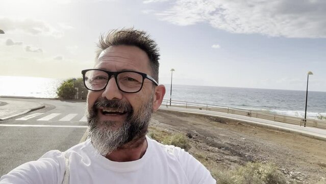 One man walking alone outdoor on the street speaking at the phone recording video or in videocall. Traveler content creator concept influencer lifestyle modern online job business. Using smartphone