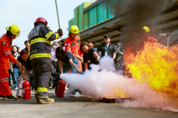Employees firefighting training, Concept Employees hand using fire extinguisher fighting fire closeup. Spray fire extinguisher.