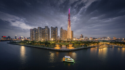 
Afternoon sunset on the tallest building in Vietnam. Below is the Saigon river and the boat is...