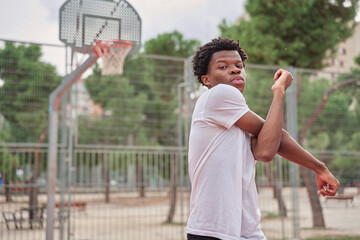 black man stretching his arms to play basketball