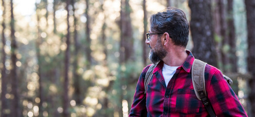 Portrait of a man hiker walking on the trail in the woods. Happy lifestyle traveling male with...