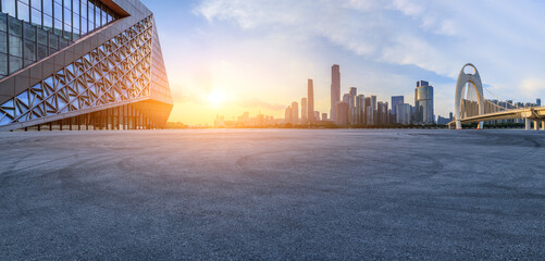 Asphalt road square and glass wall with modern city buildings at sunset in Guangzhou. Panoramic view. - obrazy, fototapety, plakaty