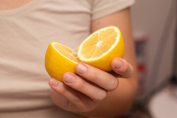 Hand Showcasing Half a Lemon. A person's fingers displaying a bright lemon half.