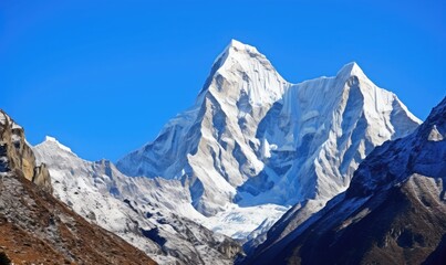 Fototapeta premium the rugged beauty of snow-capped peaks piercing the clear blue sky 