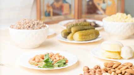 Holy Week, End, Palm Sunday, Good Friday, Easter Sunday Concept. Orthodox food in Great Christian Lent, Lenten food on a wooden table against the background of Orthodox icons.