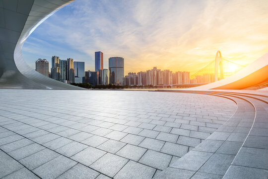 Empty square floor with modern city buildings at sunrise in Guangzhou