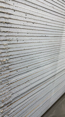 A stack of white boards with a gray stripe down the middle. The boards are stacked on top of each other, creating a tall structure. The gray stripe adds a sense of contrast