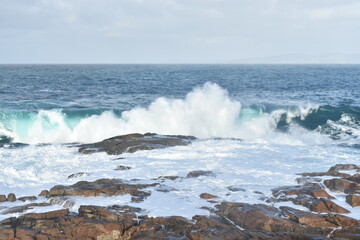 olas golpeando con las rocas la marea esta alta con un cielo celeste