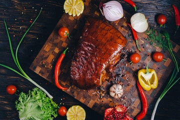 roast pork in a smokehouse, standing on a cutting board, garnished with rosemary, pepper, chili...