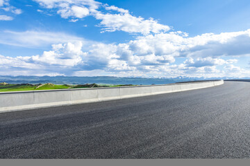 Asphalt road and mountain with sky clouds on a sunny day
