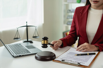 Asian female lawyer working in office or court with hammer and justice pad on table, online legal...
