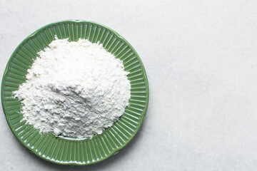All purpose flour in a green plate, baking flour in a plate on a marble countertop