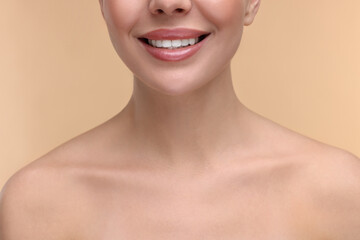 Woman with beautiful lips smiling on beige background, closeup - obrazy, fototapety, plakaty