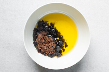 overhead view of creaming melted butter brown sugar with a whisk, the process of making chocolate chip cookies, mixing melted butter and sugar to make cake