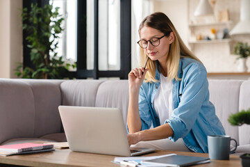 Young caucasian multitasking businesswoman working from home remotely on lockdown, student,...