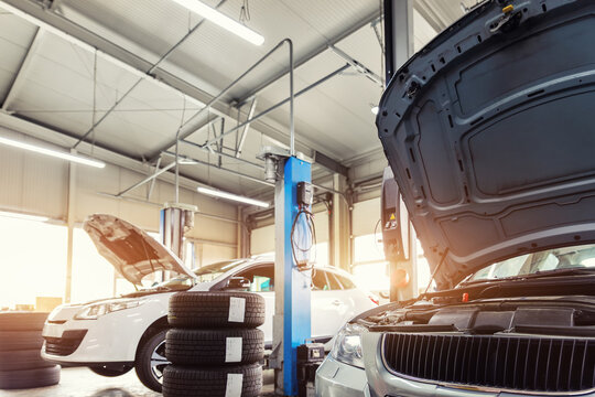Car service center garage workshop. Vehicle raised on lift at maintenance station. Automobile repair and check up. Automotive insurance and technical checkup inspection diagnostic