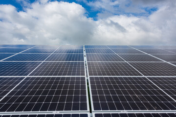 Photovoltaikanlage zur Stromerzeugung auf einem Acker vor wolkigem Himmel - 761557283