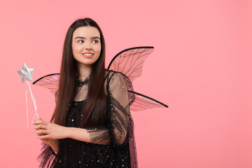 Beautiful girl in fairy costume with wings and magic wand on pink background, space for text