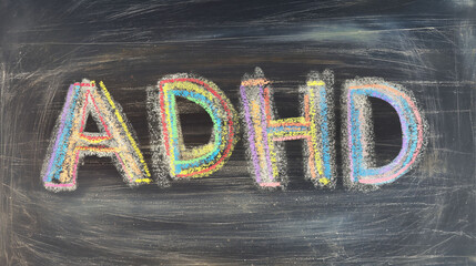 Vibrant chalk letters spelling ADHD on a classroom blackboard evoke educational and psychological themes