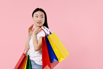 Fototapeta na wymiar Smiling woman with shopping bags on pink background. Space for text