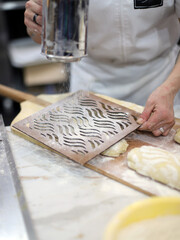 baker sprinkling flour on kneaded bread