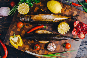 Smoked mackerel, fresh salad, croutons and lemon slices on black chalkboard background. Pub or bar table from above. Poster layout with free text space.