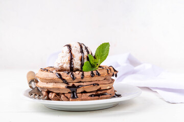 Stack of chocolate belgian waffles with ice cream and chocolate topping. Breakfast waffles with gelato, chocolate sauce drizzles and mint