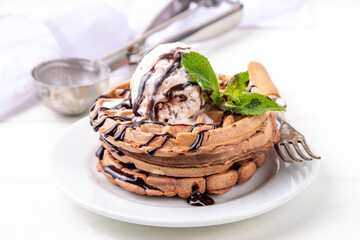 Stack of chocolate belgian waffles with ice cream and chocolate topping. Breakfast waffles with...