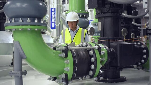 engineer work on chiller plant. worker checking pipe on chiller water plant.	