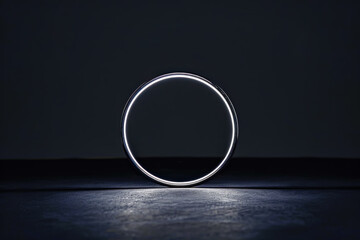 Single luminous silver hoop on a pure black background, symbolizing focus, elegance, and the beauty of simplicity