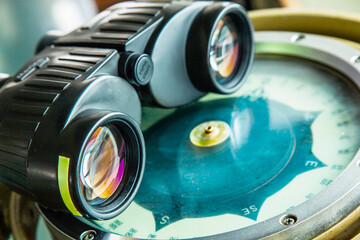 Optical binoculars lies on a gyrocompass, close-up.