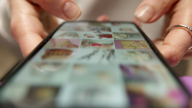 A girl is looking at a photo gallery on her phone. Online social network on a smartphone screen.