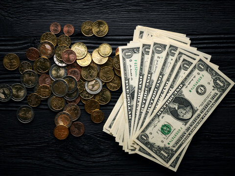 Money background with euro cents and one dollar bills over black wooden background
