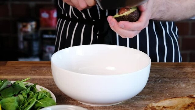 The chef takes out an avocado pit. Preparing Avocados for Avocado Toast.Slow moю Close-up