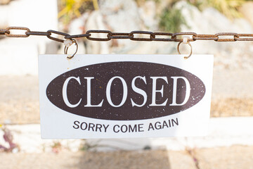 Closed sign text hanging on a chain isolated