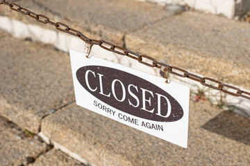 Closed sign text hanging on a chain isolated
