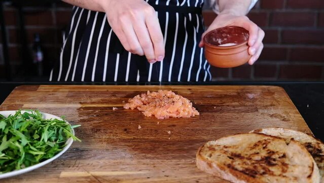 Avocado toast with fresh salmon.Fresh salmon tartare. The chef slices lightly salted fish. Slow mo.