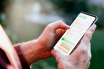 Man looking at calendar on phone, early in the morning for planning the day. Digital schedule concept.