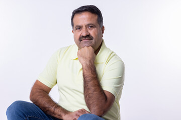 Happy mature man with arms crossed and looking at camera while standing against white background