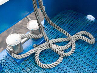 Coiled rope on a blue sailing boat deck. Sailing equipment aboard ship. Shipping concept