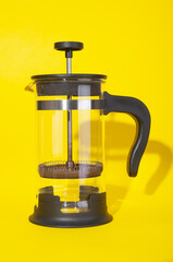 Empty french press close up  on yellow background