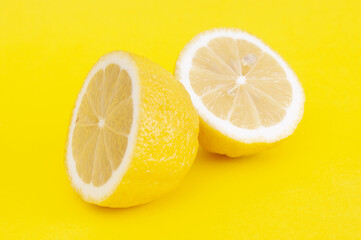 Slices of fresh lemon close up on yellow background