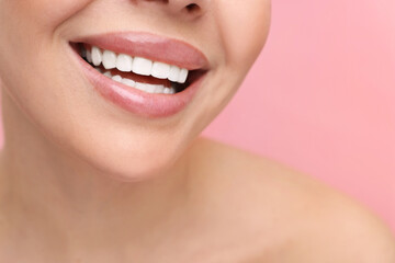 Fototapeta premium Woman with beautiful lips smiling on pink background, closeup