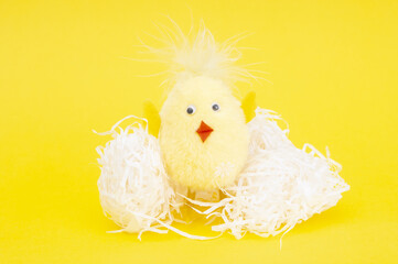 Toy little chicken close up on a yellow background